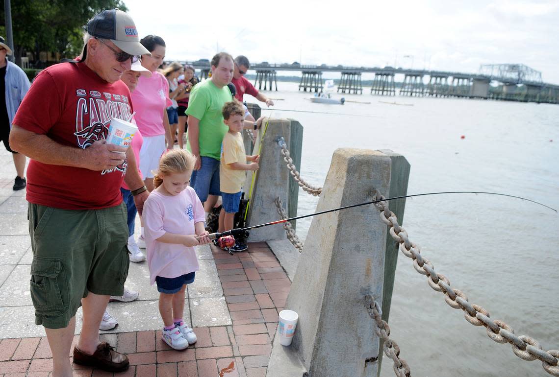 Emma Kennerly, 4, of Port Royal fishes in the Beaufort River with her grandfather, Perry Kennerly, during the Children’s Toad Fish Fishing Tournament in 2013.
