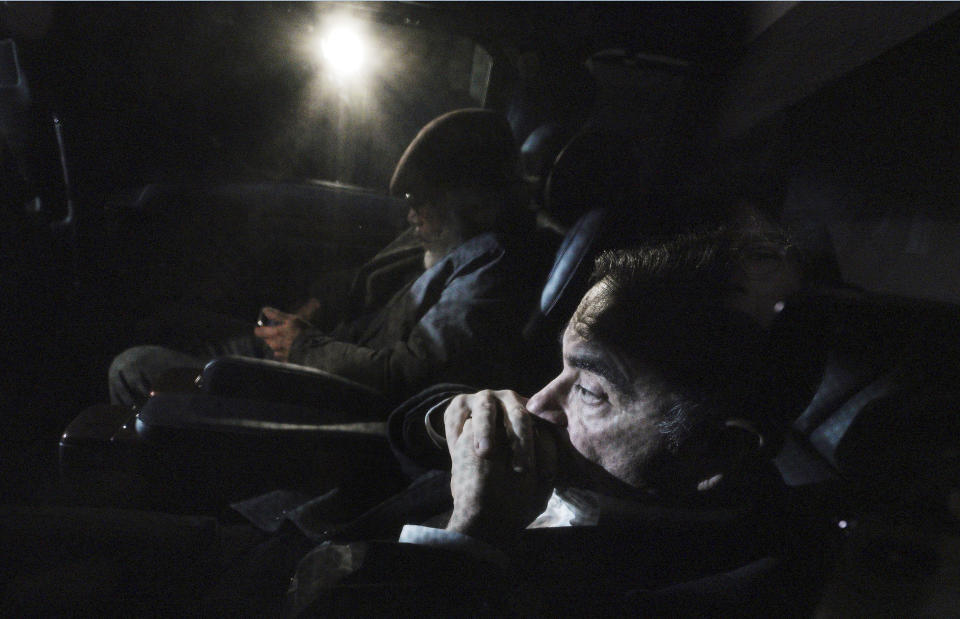 Former Nissan chairman Carlos Ghosn, front, travels in a car Wednesday, March 6, 2019, in Tokyo, after posting 1 billion yen ($8.9 million) in bail once an appeal by prosecutors against his release was rejected. Ghosn was arrested in November and is charged with falsifying financial reports and breach of trust. (AP Photo/Eugene Hoshiko)