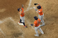Houston Astros' Jose Altuve, left, celebrates with Yainer Diaz (21) and Grae Kessinger (16) after all three scored on Altuve's home run during the ninth inning in Game 5 of the baseball American League Championship Series against the Texas Rangers Friday, Oct. 20, 2023, in Arlington, Texas. (AP Photo/Godofredo A. Vásquez)