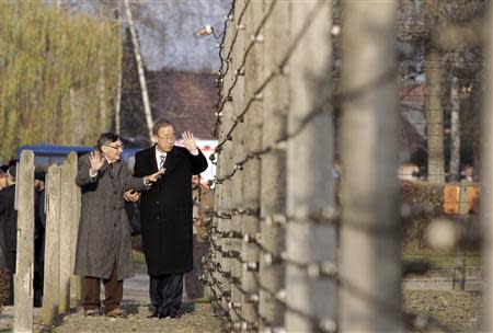 U.N. Secretary General Ban Ki-moon walks along an electric barbed-wired fence with holocaust survivor and Council for the Museum of the History of Polish Jews chairman Marian Turski (L) during his visit to the Auschwitz-Birkenau memorial and former concentration camp November 18, 2013. REUTERS/Kacper Pempel