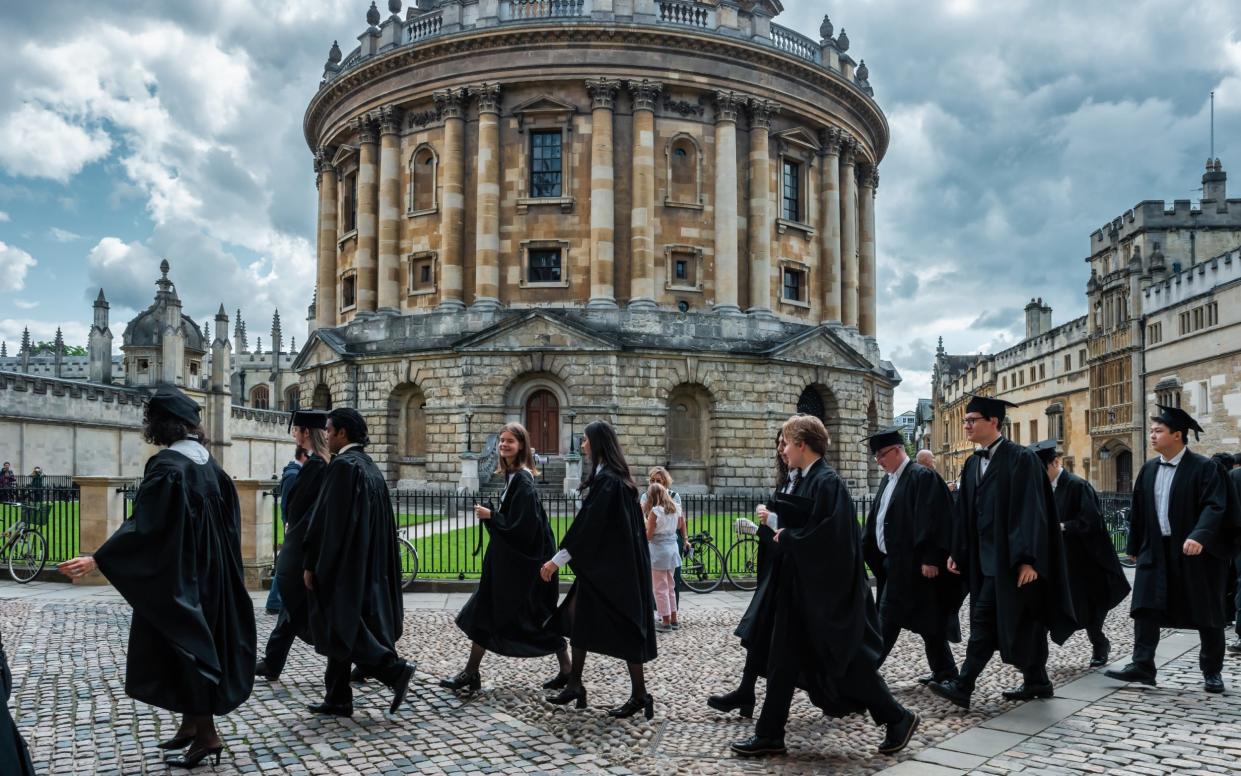 Graduands walk past Radcliffe Camera during a graduation ceremony in Oxford