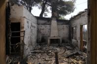 A burned house after a wildfire in Varibobi area, northern Athens, Greece, Wednesday, Aug. 4, 2021. Firefighting planes were resuming operation at first light Wednesday to tackle a major forest fire on the northern outskirts of Athens which raced into residential areas the previous day, forcing thousands to flee their homes amid Greece's worst heatwave in decades. (AP Photo/Thanassis Stavrakis)