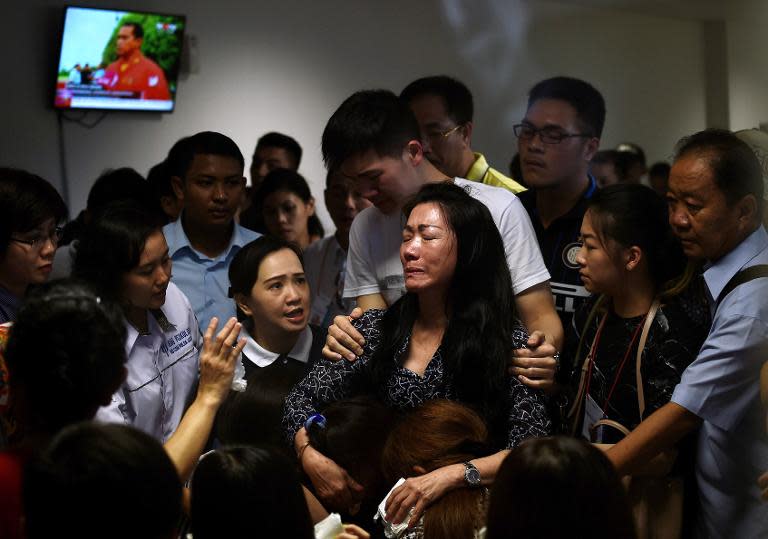 Family members of passengers onboard AirAsia flight QZ8501 react after watching news reports showing an unidentified body floating in the Java sea, inside the crisis-centre set up at Juanda International Airport