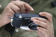 BERLIN, GERMANY - AUGUST 30: A visitor tries out the new Samsung Galaxy Camera, which combines a smartphone and a digital camera with a zoom lens, during a press day at the Samsung stand at the IFA 2012 consumer electronics trade fair on August 30, 2012 in Berlin, Germany. IFA 2012 will be open to the public from August 31 through September 5. (Photo by Sean Gallup/Getty Images)