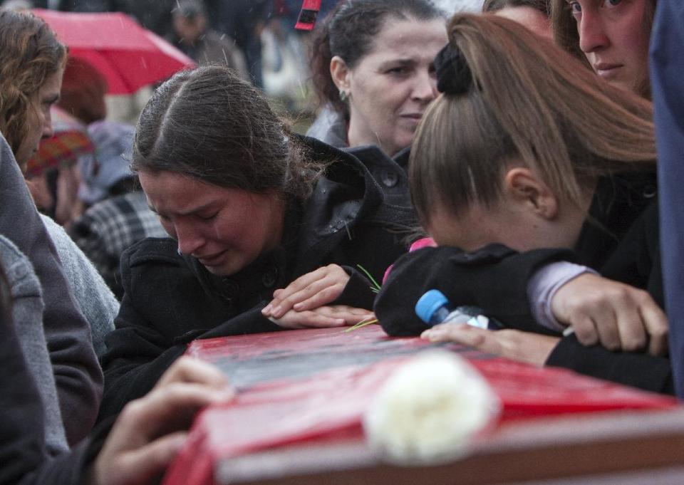 Ethnic Albanian women weep during the funeral ceremony of 19 ethnic Albanians killed during the 1998-99 Kosovo war in the town of Mala Krusa on Wednesday, March 26, 2014. The victims were killed in two separate rampages by Serbs forces in town of Suva Reka and Mala Krusa just days after NATO began a bombing campaign to end an onslaught by Serbia on separatist ethnic Albanians. (AP Photo/Visar Kryeziu)