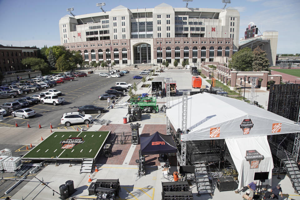 FILE - Workers set up the ESPN "College GameDay" stage in front of Memorial Stadium in Lincoln, Neb., Sept. 26, 2019. “College GameDay” has continued its reign as the preeminent pregame show leading into Saturday afternoon kickoffs. But the ESPN franchise goes into its 37th year with the most changes it has had going into a season as well as facing competition from Fox and its upstart “Big Noon Kickoff.” (AP Photo/Nati Harnik, File)