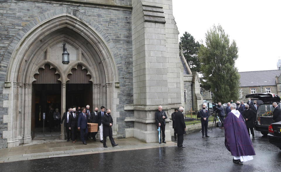 The coffin of the former Northern Ireland lawmaker and Nobel Peace Prize winner John Hume is carried from funeral Mass at St Eugene's Cathedral, pall bearers include his son John Hume, front center, with other family members in Londonderry, Northern Ireland, Wednesday, Aug. 5, 2020. Hume was co-recipient of the 1998 Nobel Peace Prize with fellow Northern Ireland lawmaker David Trimble, for his work in the Peace Process in Northern Ireland. Masks are worn due to the ongoing Coronavirus outbreak . (AP Photo/Peter Morrison)