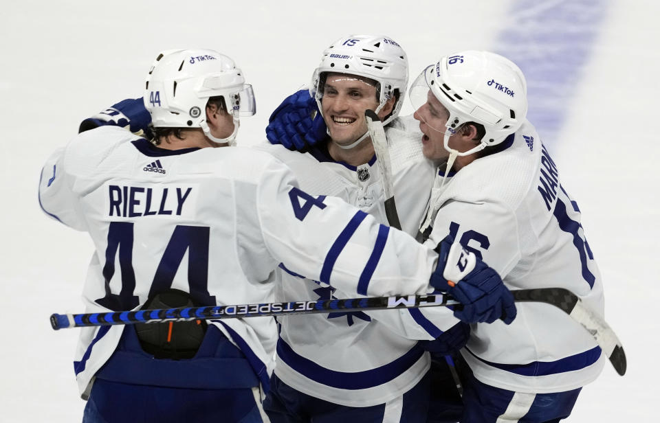 Toronto Maple Leafs defenseman Morgan Rielly, left, and right wing Mitchell Marner, right, congratulate center Alexander Kerfoot, center, after he scored the winning goal in a shootout during NHL hockey game action against the Ottawa Senators in Ottawa, Ontario, Saturday, March 18, 2023. (Adrian Wyld/The Canadian Press via AP)