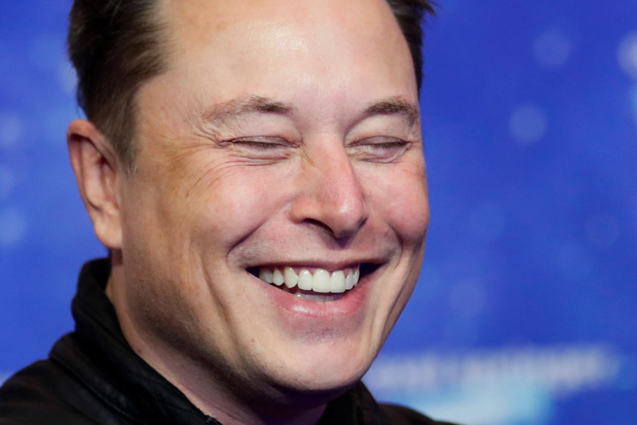 SpaceX owner and Tesla CEO Elon Musk (R) gestures as he arrives on the red carpet for the Axel Springer Awards ceremony, in Berlin, on December 1, 2020. (Photo by HANNIBAL HANSCHKE / POOL / AFP) (Photo by HANNIBAL HANSCHKE/POOL/AFP via Getty Images)