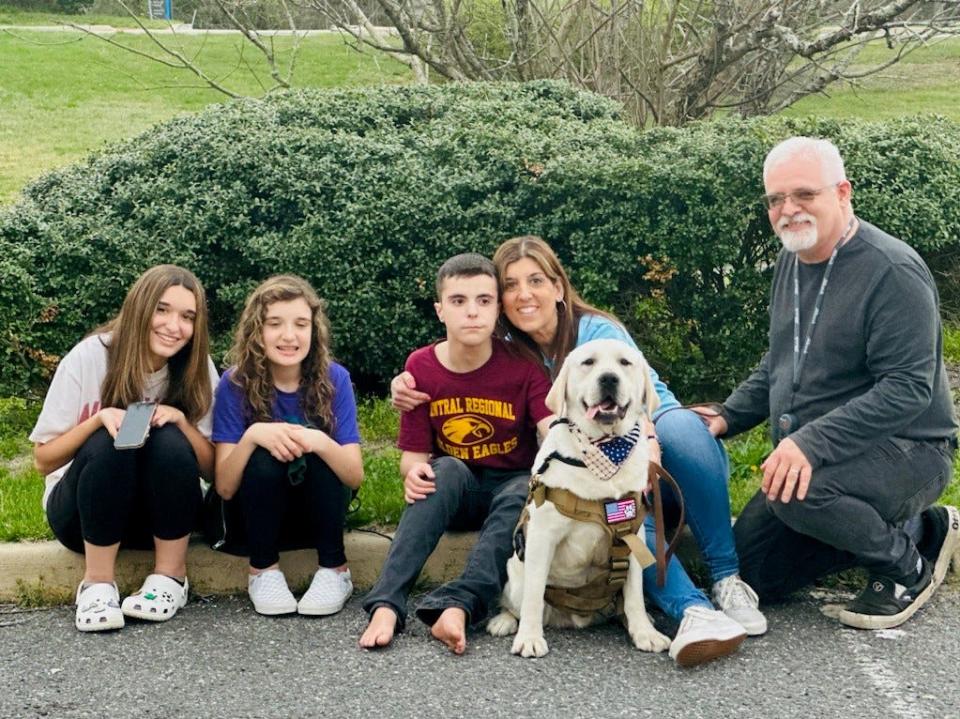 Ryan Lawrence (center) and family members with his new service dog Boo