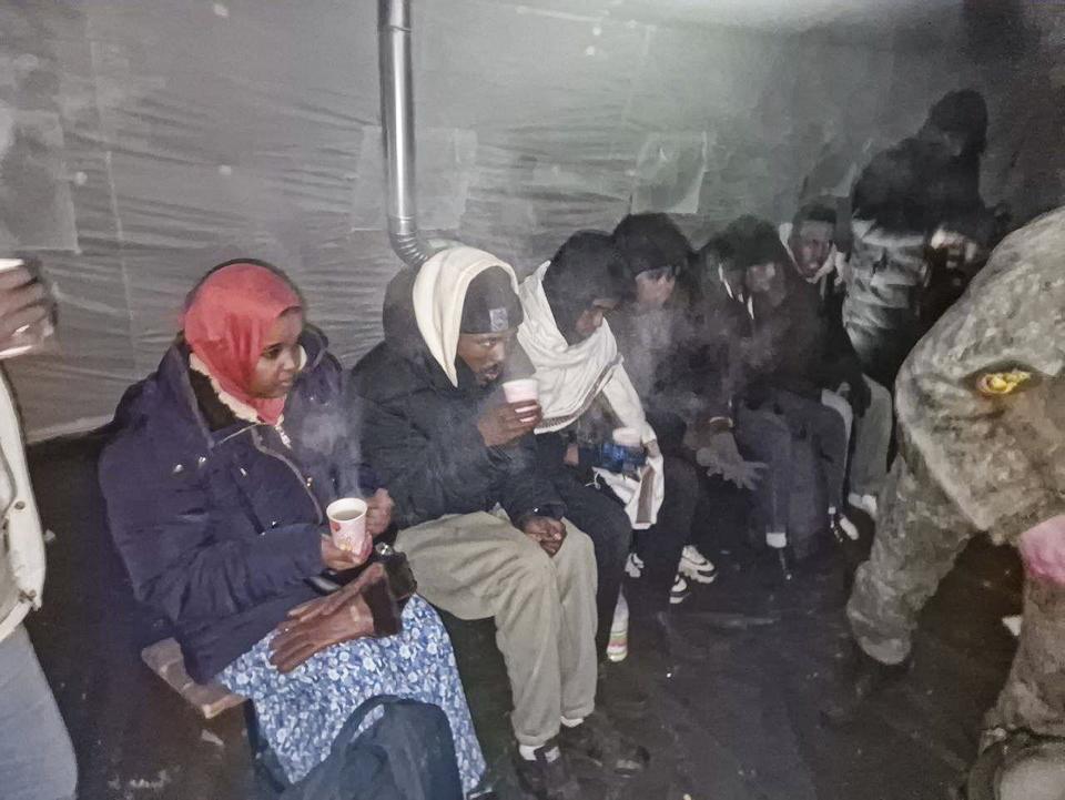 This handout photo released by Governor of Murmansk region Andrey Chibis' telegram channel on Wednesday, Nov. 22, 2023, Migrants gather getting hot drink inside a tent near the border with Finland at the Salla checkpoint, one of the still open border checkpoints situated in the Kandalaksha district of the Murmansk region, about 1300 km (812 miles) north of Moscow, Russia. (Governor of Murmansk region Andrey Chibis' telegram channel via AP)