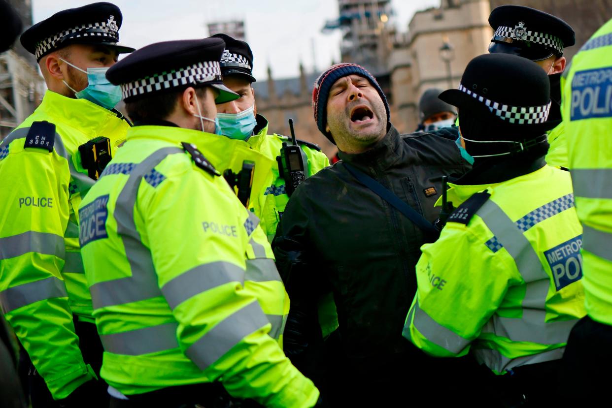 <p>Police detain a protestor during anti-lockdown demonstrations outside the Houses of Parliament</p> (AFP via Getty Images)