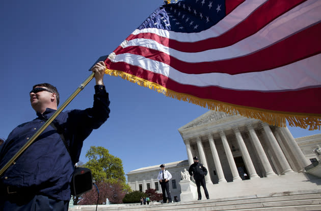 Holding an American flag and a copy of the Constitution, Dan, who asked not to use his last name, of Virginia, protests against the health care law.