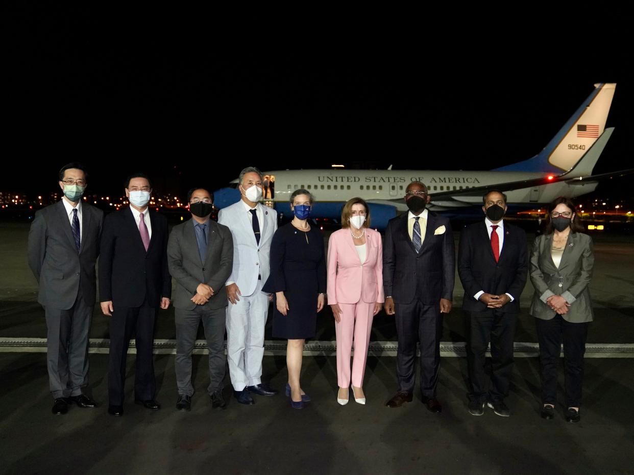 US House Speaker Nancy Pelosi, center pose for photos after she arrives in Taipei, Taiwan, Tuesday, Aug. 2, 2022.