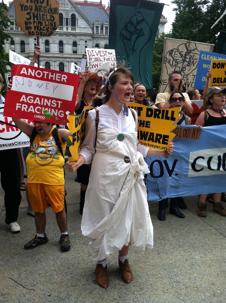 Emily Wilson of Ithaca wears an angel costume during a demonstration in Albany Monday, Aug. 27, 2012, telling Gov. Andrew Cuomo to ban shale gas drilling using hydraulic fracturing, or "fracking," in New York state. She was among more than 1,000 anti-fracking protesters who marched to the state Capitol on Monday. (AP Photo/Mary Esch)