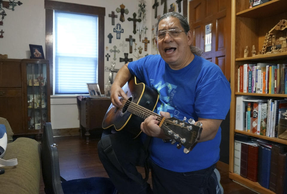 Music minister Roland Guerrero plays the praise song "Montaña" on his guitar at his house in El Paso, Texas, on Sunday, April 3, 2022. For nearly all Sundays since last Easter, Guerrero has sung and played this and other sacred music at Masses celebrated at a shelter on nearby Fort Bliss Army base for unaccompanied minors who crossed the U.S.-Mexican border. (AP Photo/Giovanna Dell'Orto)