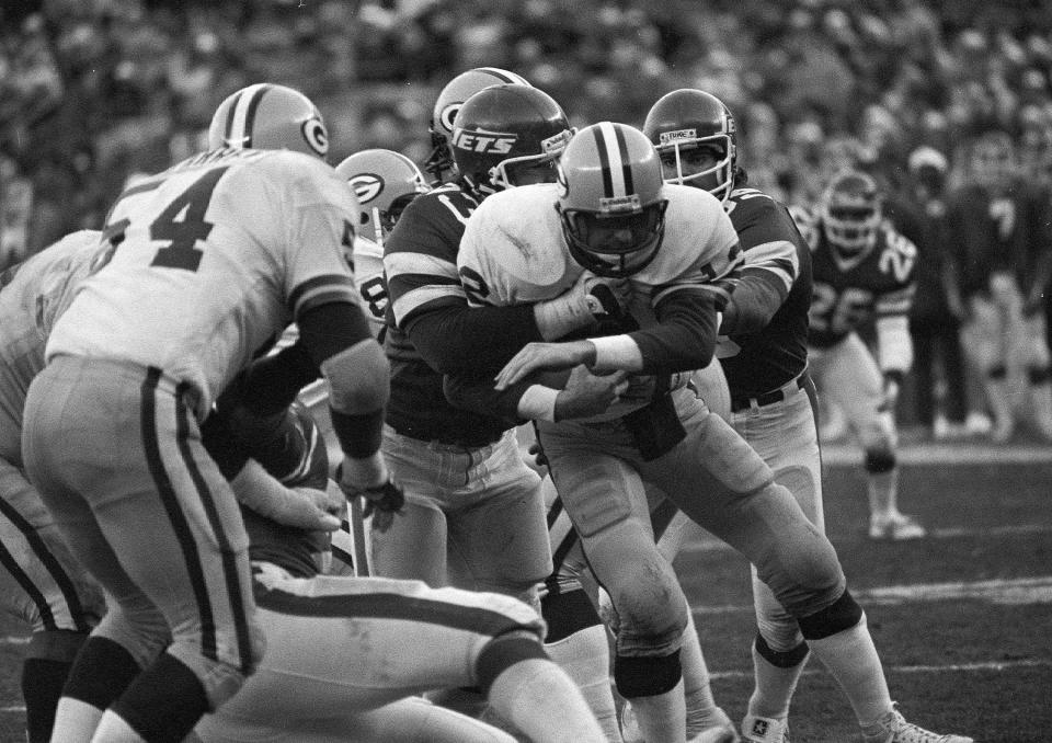Jets defensive ends Joe Klecko (left) and Mark Gastineau put the squeeze on Green Bay Packers quarterback Lynn Dickey for one of nine sacks at Shea Stadium in New York, Dec. 20, 1981.