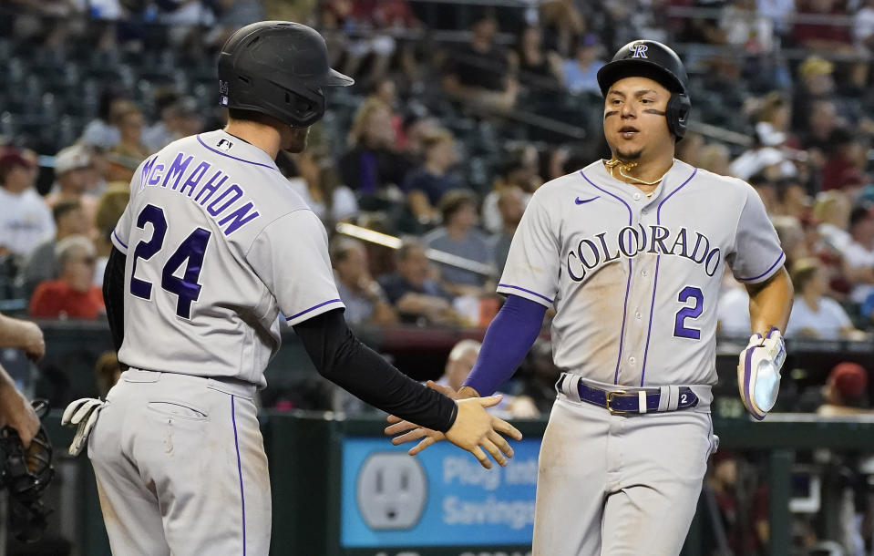 Colorado Rockies' Ryan McMahon (24) congratulates Yonathan Daza (2) as he scores their second run against the Arizona Diamondbacks during the seventh inning of a baseball game, Sunday, July 10, 2022, in Phoenix. (AP Photo/Darryl Webb)