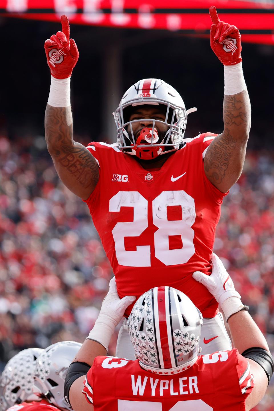 Buckeyes running back Miyan Williams (28) celebrates with lineman Luke Wypler (53) after scoring in the first half against the Spartans.