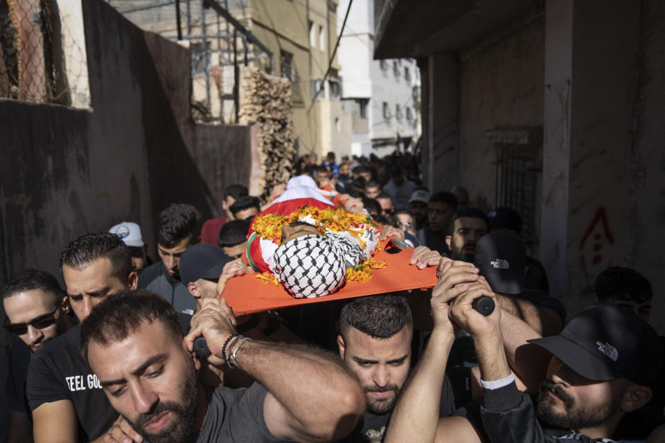 Palestinos cargan con el cadáver de Ibrahim Zayed, de 29 años, durante su funeral en el campo de refugiados cisjordano de Qalandia, el 3 de noviembre de 2023, al sur de Ramallah. (AP Foto/Nasser Nasser)