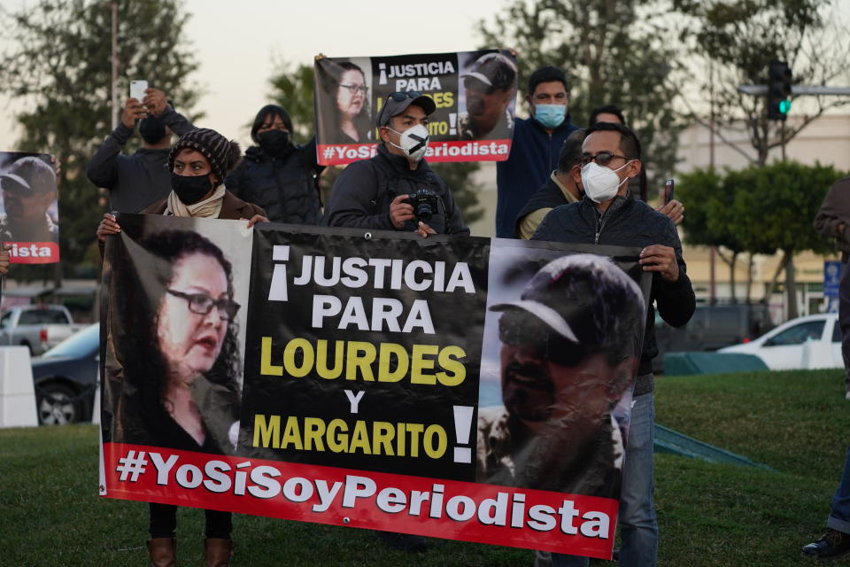 People hold a sign that reads in Spanish "Justce for Lourdes and Margarito," during a national protest against the murder of journalist Lourdes Maldonado and freelance photojournalist Margarito Martínez, at the Mexico monument in Tijuana, Mexico, Tuesday, Jan. 25, 2022. Mexico's Interior Undersecretary Alejandro Encinas said recently that more than 90% of murders of journalists and rights defenders remain unresolved, despite a government system meant to protect them. (AP Photo/Marco Ugarte)