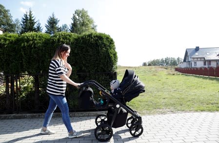 Karolina Burczyk walks her son Leon on a street in Nowa Karczma