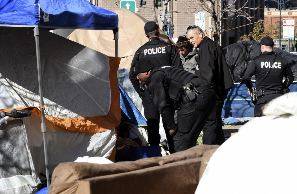 Police tell homeless people they need to leave the area during a sweep of an encampment in downtown Denver on Tuesday, Oct. 31, 2023. More cities across the U.S. are cracking down on homeless tent encampments that have grown more visible and become unsafe. (AP Photo/Thomas Peipert)