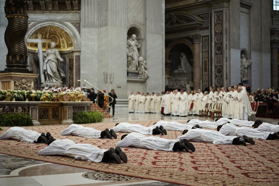 Thirteen new priests lay on the ground during a ceremony in which Pope Francis ordained them, in St. Peter's Basilica at the Vatican, Sunday, May 11, 2014. (AP Photo/Andrew Medichini)