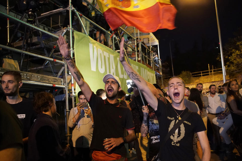 Young men raise their right arm making the the fascist salute outside the headquarters of far-right Vox party in Madrid, while supporters wait for the results of Spain's general election, Sunday, July 23, 2023. Polls have closed in Spain's national election as the country's left-wing government faces a risk of being ousted by conservatives and the far-right. (AP Photo/Andrea Comas)