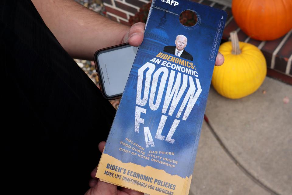 Tyler Raygor, deputy state director for Americans For Prosperity-Iowa, displays a door hanger message he leaves at houses in Urbandale, Iowa, on Thursday, Nov. 16, 2023. | Sam Benson, Deseret News