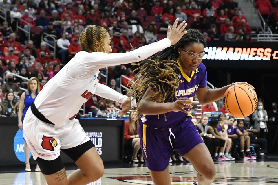 Albany guard Kayla Cooper (20) drives past Louisville guard Ahlana Smith (2) during the first half of their women's NCAA Tournament college basketball first round game in Louisville, Ky., Friday, March 18, 2022. (AP Photo/Timothy D. Easley)
