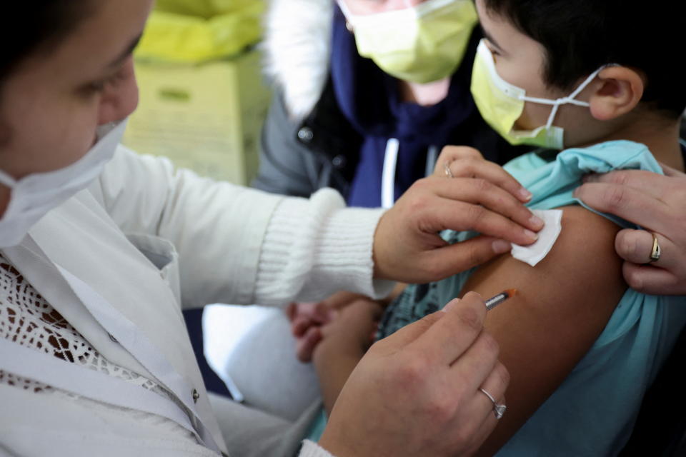A medical worker administers a dose of a COVID-19 vaccine to a child in Paris. Singapore will begin its vaccination drive for children aged five to 11 from 27 December.