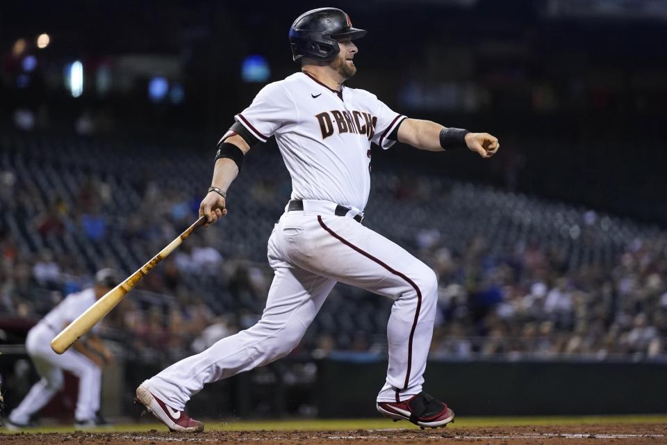 Arizona Diamondbacks' Stephen Vogt watches his run-scoring single get through to the infield during the second inning of a baseball game against the Milwaukee Brewers' Monday, June 21, 2021, in Phoenix. (AP Photo/Ross D. Franklin)