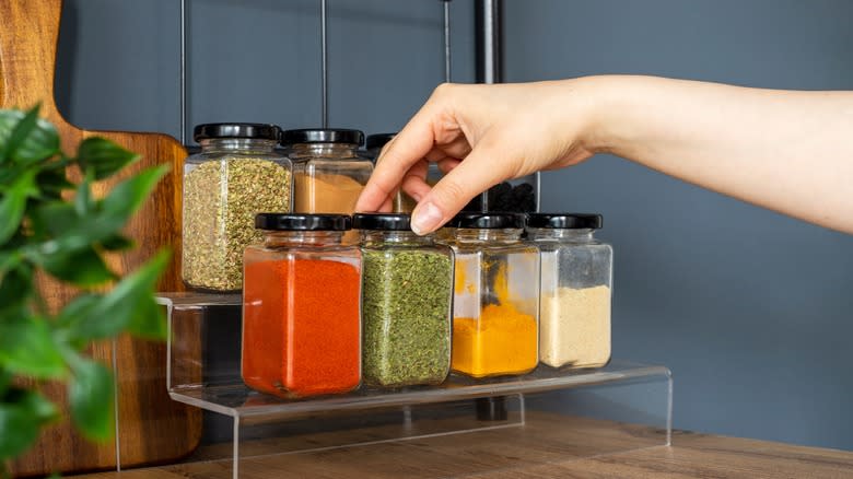 Person reaching for dried herbs