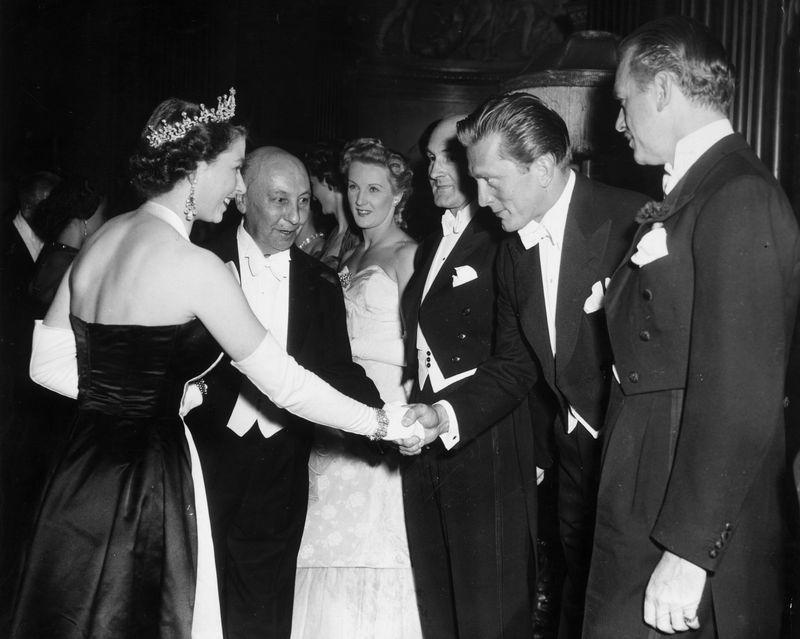 <p>When meeting Queen Elizabeth at the Royal Command premiere of <em>Because You’re Mine</em>, Kirk Douglas looked the very definition of dashing in a classic white tie tuxedo—he even treated the Queen to a bow. What a class act.</p>