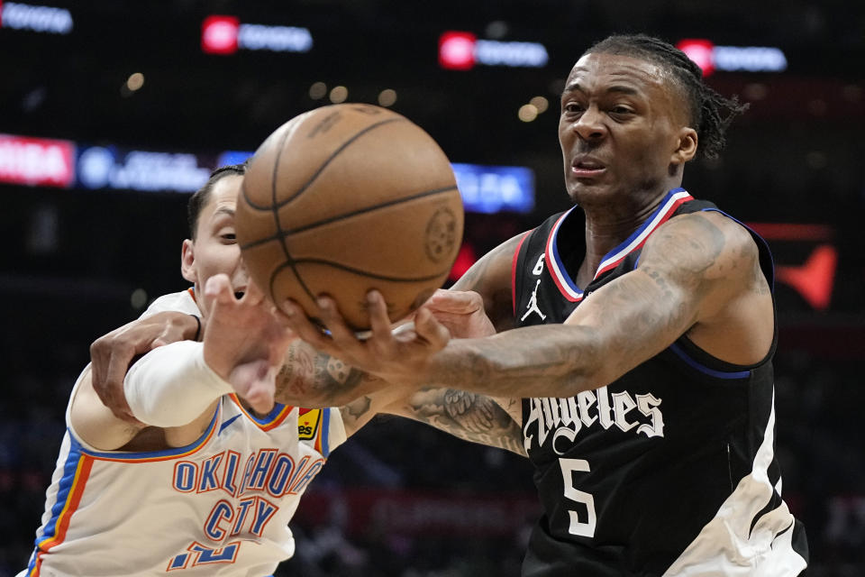 Oklahoma City Thunder forward Lindy Waters III, left, and LA Clippers guard Bones Hyland reach for a loose ball during the second half of an NBA basketball game Thursday, March 23, 2023, in Los Angeles. (AP Photo/Mark J. Terrill)