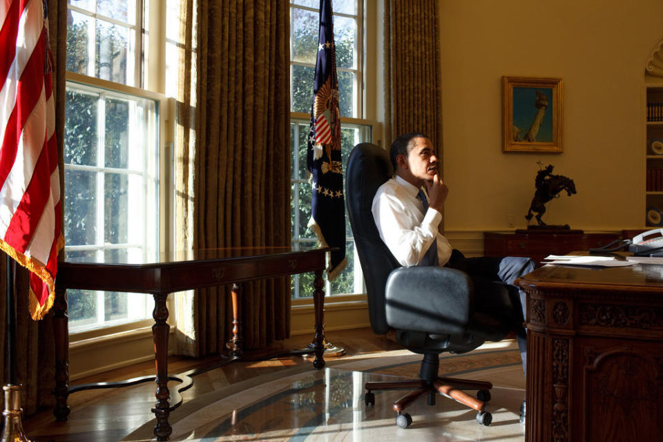 Obama sits in the Oval Office on his first day in office, Jan. 21, 2009.