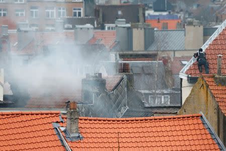 Belgium police officer secures the area from a rooftop at the scene where shots were fired during a police search of a house in the suburb of Forest near Brussels, Belgium, March 15, 2016.