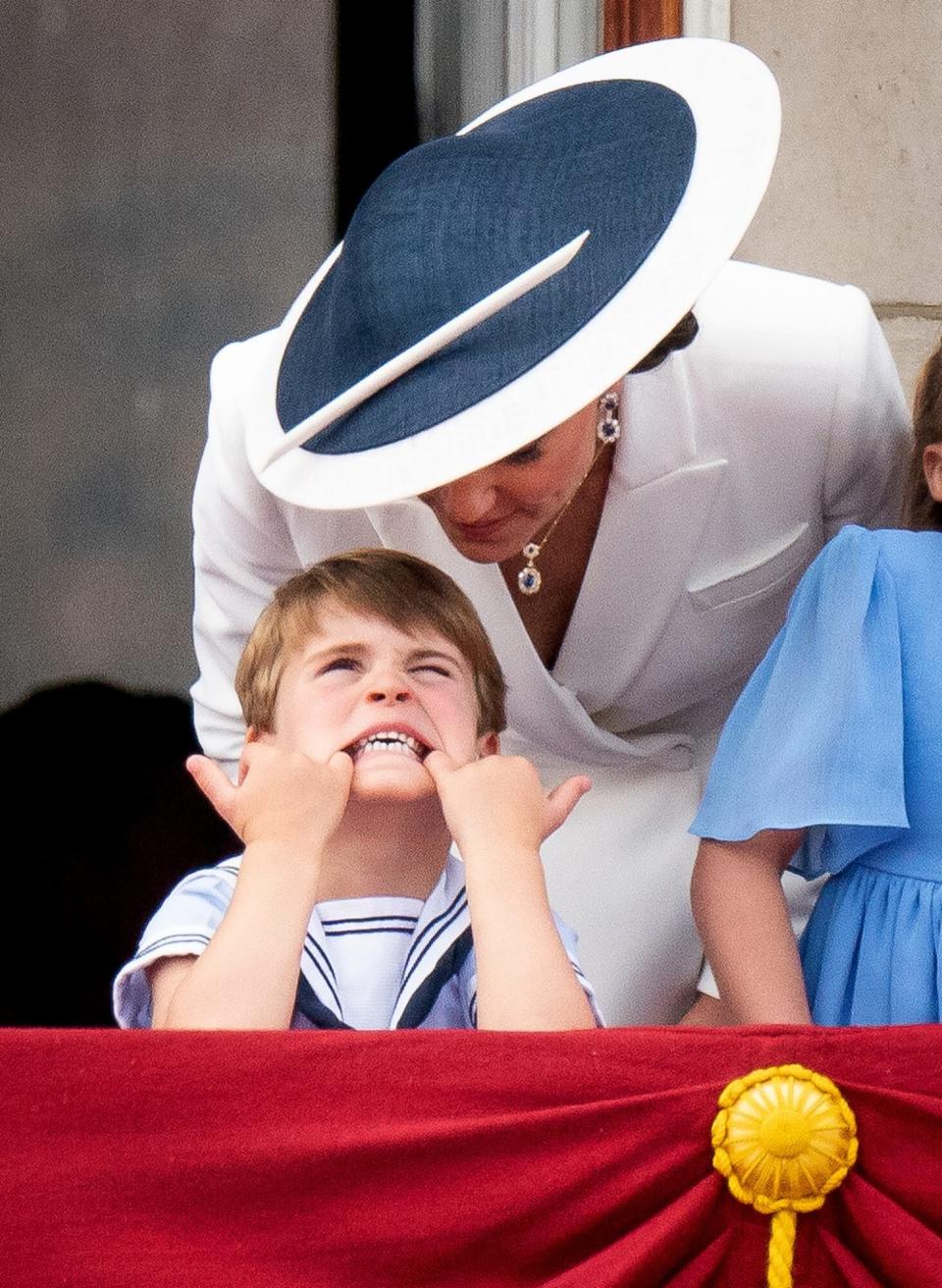 The Duchess of Cambridge speaks to prince Louis as he pulls a face on the balcony of Buckingham Palace, to view the Platinum Jubilee flypast, on day one of the Platinum Jubilee celebrations