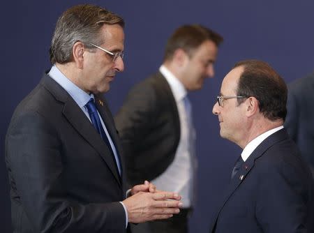 France's President Francois Hollande (R) talks Greece's Prime Minister Antonis Samaras as they pose for a family photo during an EU summit in Brussels October 23, 2014. REUTERS/Christian Hartmann