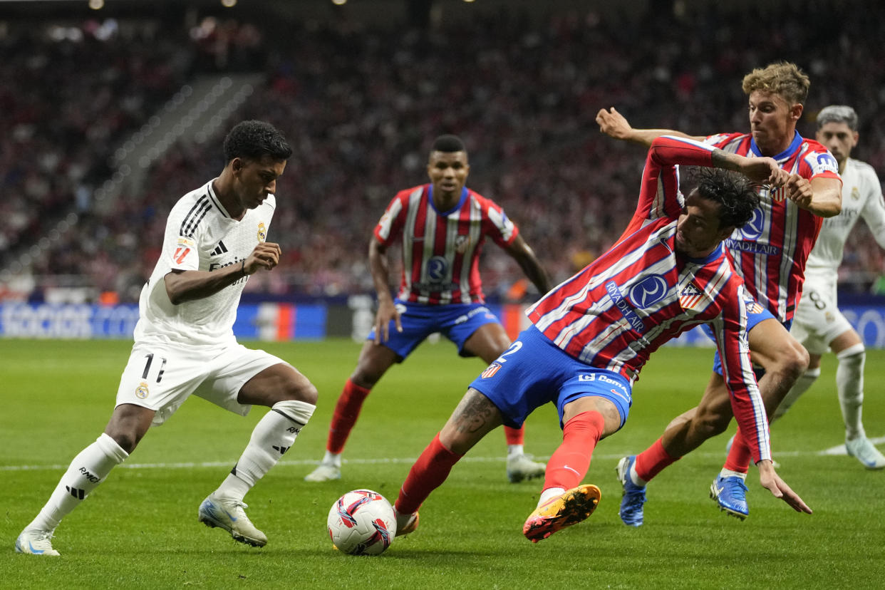 Real Madrid's Rodrygo, left, and Atletico Madrid's Jose Gimenez fight for the ball during the La Liga soccer match between Atletico Madrid and Real Madrid at the Metropolitano stadium in Madrid, Spain, Sunday, Sept. 29, 2024. (AP Photo/Bernat Armangue)