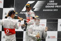 SHANGHAI, CHINA - APRIL 15: Race winner Nico Rosberg (R) of Germany and Mercedes GP celebrates with second placed Jenson Button (L) of Great Britain and McLaren and third placed Lewis Hamilton (C) of Great Britain and McLaren on the podium following the Chinese Formula One Grand Prix at Shanghai International Circuit on April 15, 2012 in Shanghai, China. (Photo by Gu Zhichao/Sports Illustrated China/Getty Images)