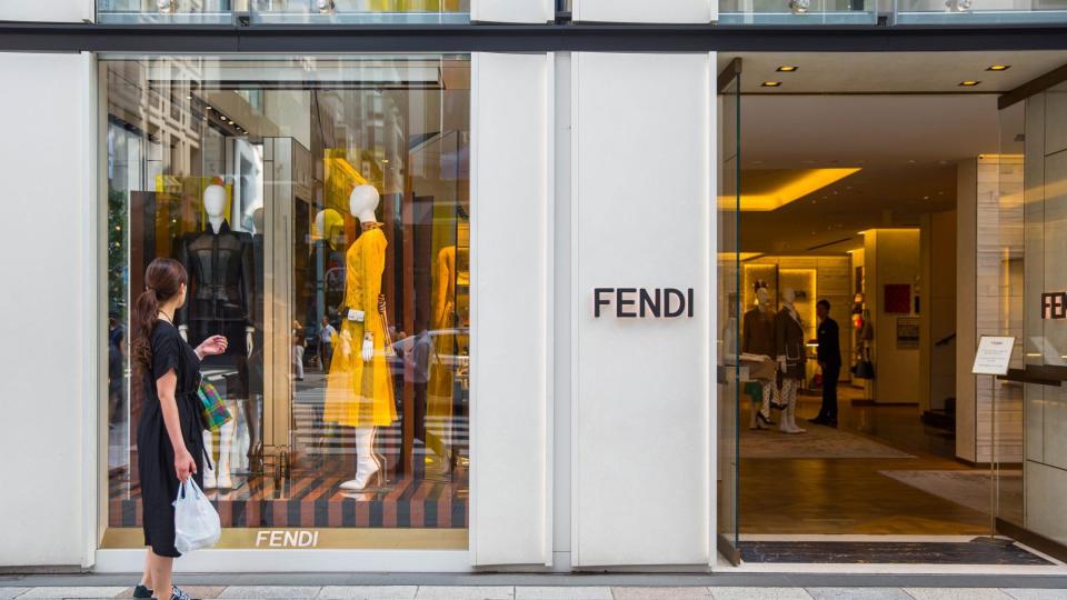 A woman looks inside a Fendi store window in Ginza