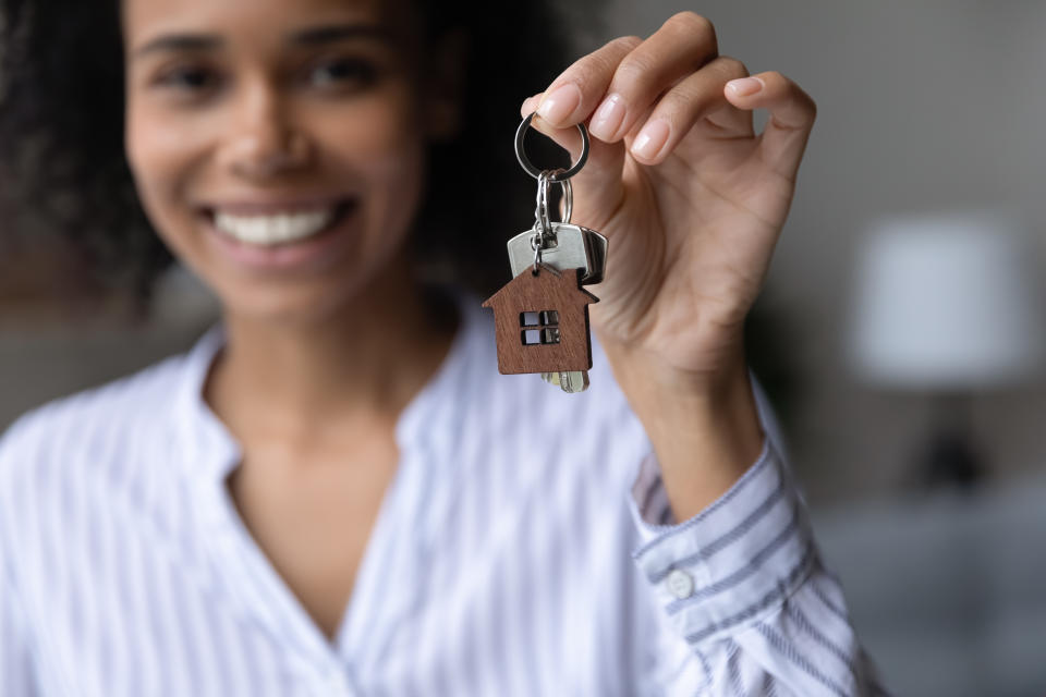 Gros plan sur les clés dans la main heureuse d'une femme afro-américaine, souriante satisfaite jeune propriétaire locataire excitée par la relocalisation, achetant son premier appartement, concept de propriété et de sécurité