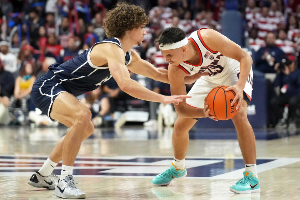 Arizona guard Kerr Kriisa (25) shields the ball from Utah Tech guard Isaiah Pope, left, during the second half of an NCAA college basketball game, Thursday, Nov. 17, 2022, in Tucson, Ariz. (AP Photo/Rick Scuteri)