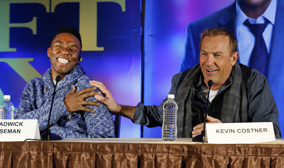 Actors Chadwick Boseman, left, and Kevin Costner appear at a news conference for the movie "Draft Day" in New York on Friday, Jan. 31, 2014, two days before the NFL football Super Bowl in East Rutherford, N.J. (AP Photo/Paul Sancya)