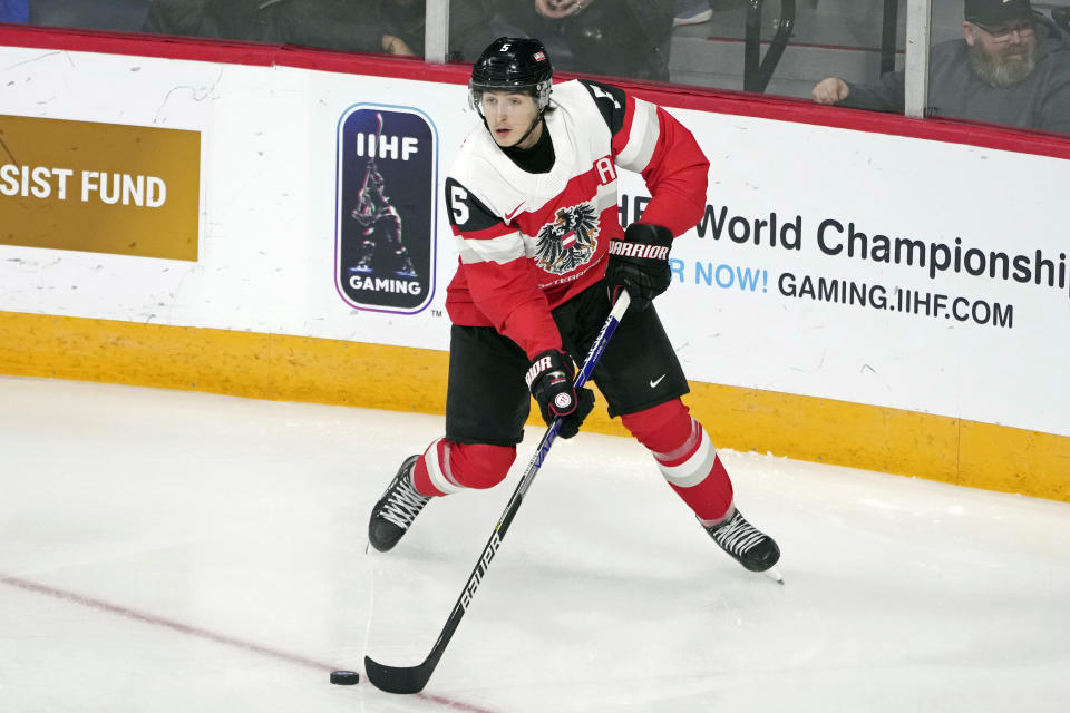 FILE - Austria's David Reinbacher handles the puck during the first period against Germany at the world junior hockey championships in Halifax, Nova Scotia, Friday, Dec. 30, 2022. In an NHL draft class dominated by skilled forwards, and led by Connor Bedard, questions arise over who and when the first defenseman will be selected when the first round is held in Nashville on Wednesday night. The leading candidate is considered to be Austria's David Reinbacher followed by Sweden's Axel Sandin Pellikka. (Darren Calabrese/The Canadian Press via AP, FIle)