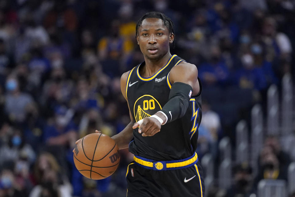 Golden State Warriors forward Jonathan Kuminga dribbles the ball up the court against the Utah Jazz during the first half of an NBA basketball game in San Francisco, Sunday, Jan. 23, 2022. (AP Photo/Jeff Chiu)