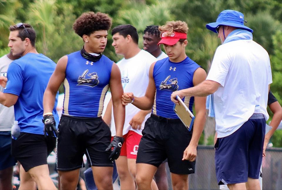 Cardinal Newman running back Tovani Mizell (left) goes over the Crusaders' game plan with QB Davi Belfort (right) at Keiser University's 7-on-7 tournament in July.
