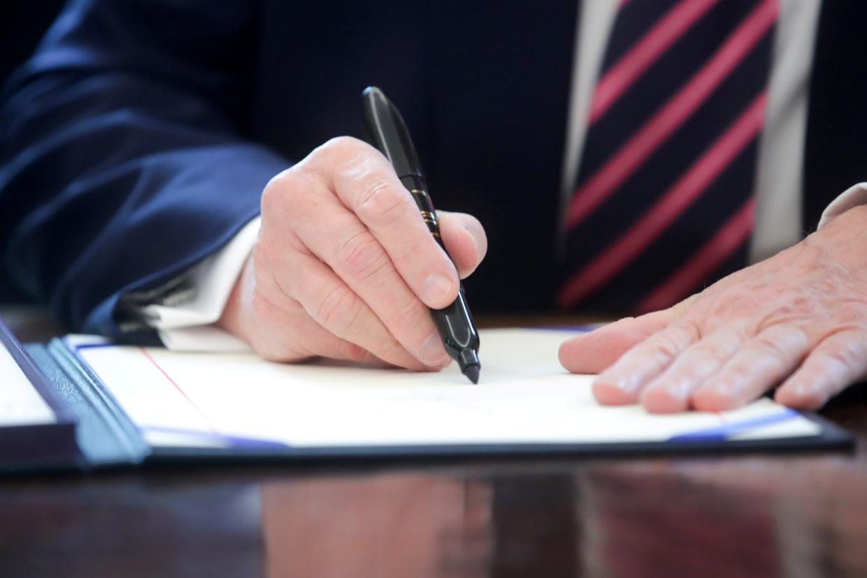 FILE PHOTO: U.S. President Donald Trump signs the Paycheck Protection Program and Health Care Enhancement Act financial response to the coronavirus disease (COVID-19) outbreak, in the Oval Office at the White House in Washington, U.S. April 24, 2020.  REUTERS/Jonathan Ernst/File Photo